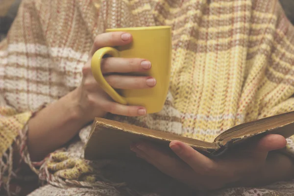 Frau auf dem Bett mit altem Buch und Tasse Kaffee in der Hand, Aussichtspunkt von oben. Kopierraum für Text. Weiches Foto — Stockfoto