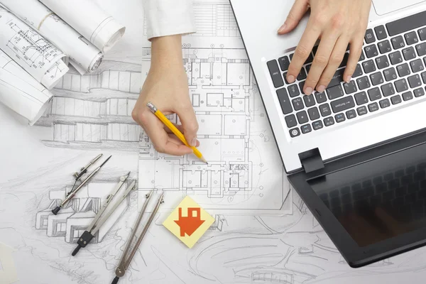 Architect working on blueprint. Architects workplace - architectural project, blueprints, ruler, calculator, laptop and divider compass. Construction concept. Engineering tools