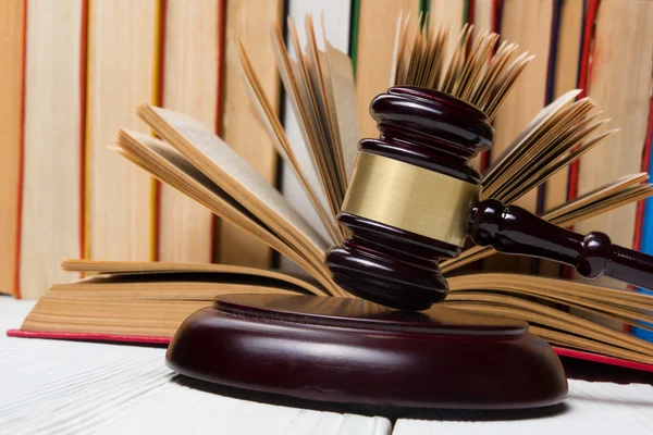 Libro de la ley con jueces de madera martillo en la mesa en una sala de tribunal o la oficina de aplicación de la ley . —  Fotos de Stock