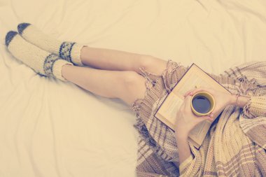 Eski kitap ve kahve ellerini, üstten bakış noktası yatağa kadın. Metin için yer kopyalayın. Yumuşak fotoğraf