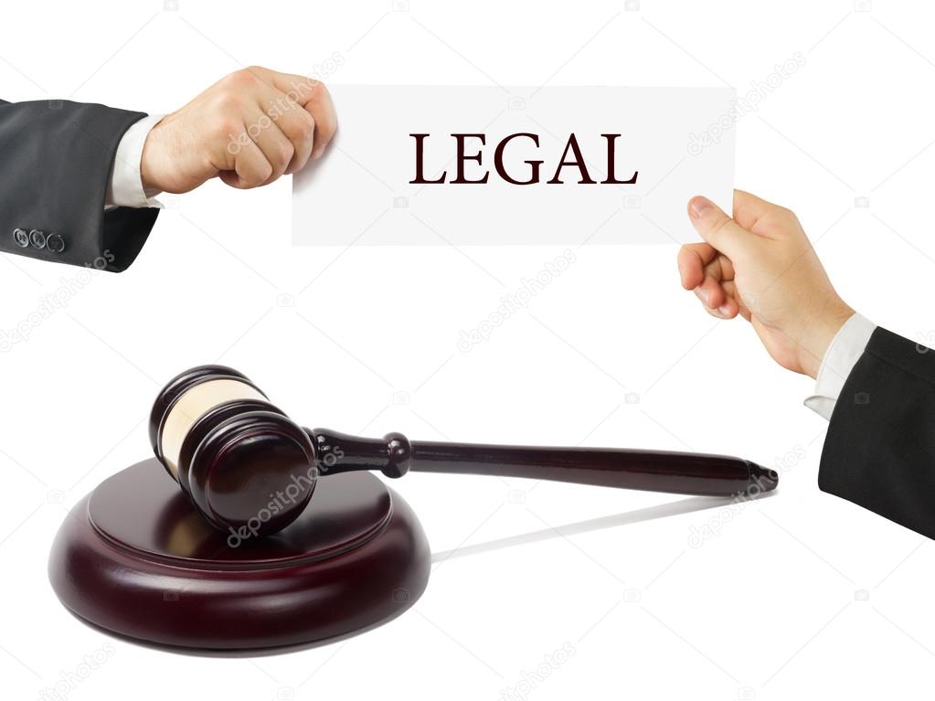 Wooden judges gavel on table in a courtroom or law enforcement office. Lawyer Hands holding business card with text Legal
