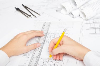 Mimar, planlar üzerinde çalışıyor. Mimarlar işyeri - mimari proje, planlar, cetvel, hesap makinesi, dizüstü bilgisayar ve bölücü pusula. İnşaat konsepti. Mühendislik araçları