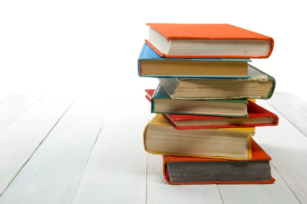 Pilha de livros na prateleira de madeira isolada no fundo branco. De volta à escola. Espaço de cópia para texto — Fotografia de Stock