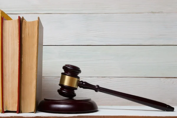 Книга законов с деревянными судьями молотком на столе в зале суда или в офисе правоохранительных органов . — стоковое фото