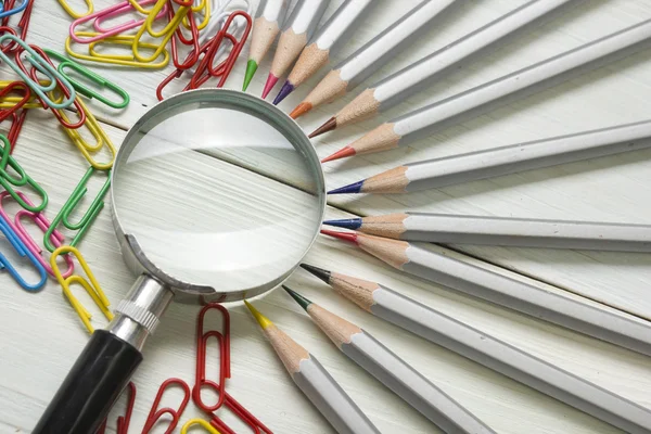 Magnifying glass, pencils on wooden table. Copy space for text. Search idea concept — Stock Photo, Image