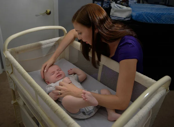 Madre Calmando Bebé Llorando Cuna Por Noche Enfermo Insomne Fotos de stock