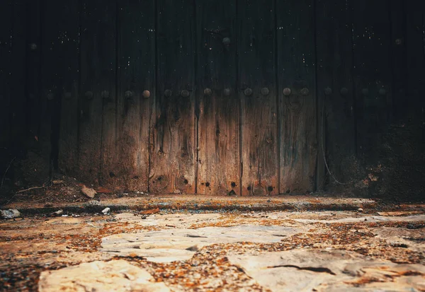 Stone floor and wall background. Close-up view of the street floor.Cobblestone floor and aged wooden door in the city