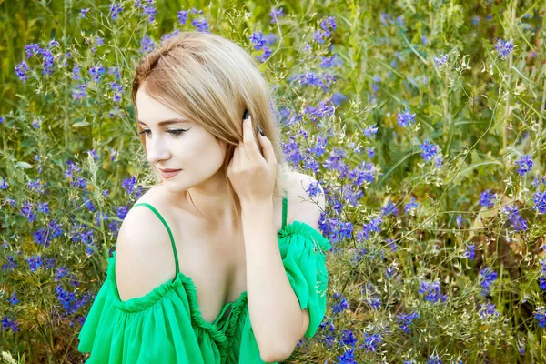 穿着绿色衣服 背景为蓝色花朵的女孩 — 图库照片