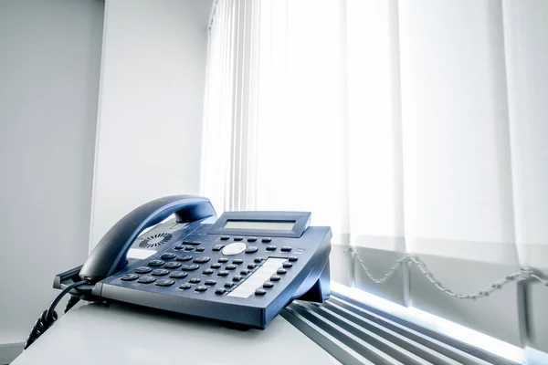 Telefone em uma janela de escritório — Fotografia de Stock