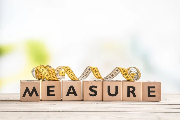 Measure word on a wooden table — Stock Photo, Image