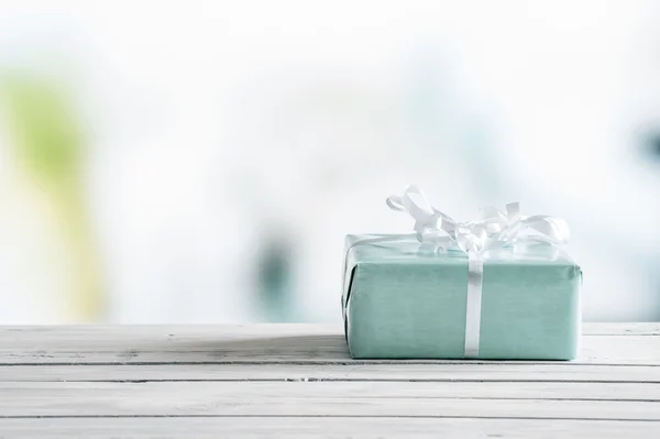 Ahşap bir masa üzerinde mavi hediye kutusu — Stok fotoğraf