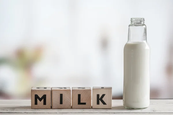 Пляшка молока і слово молоко — стокове фото