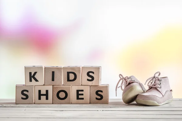 Kids schoenen op een houten bureau — Stockfoto