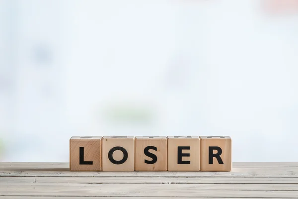Loser sign on a wooden desk — Stock Photo, Image