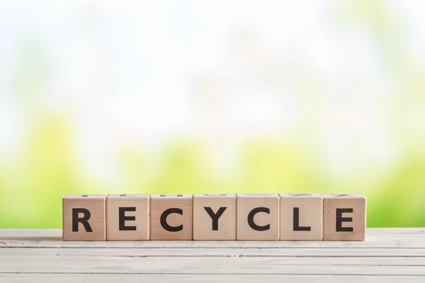 Sinal de reciclagem em uma mesa de madeira — Fotografia de Stock