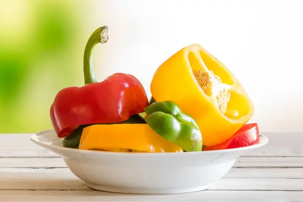 Placa con fruta de pimienta en una mesa de madera — Foto de Stock