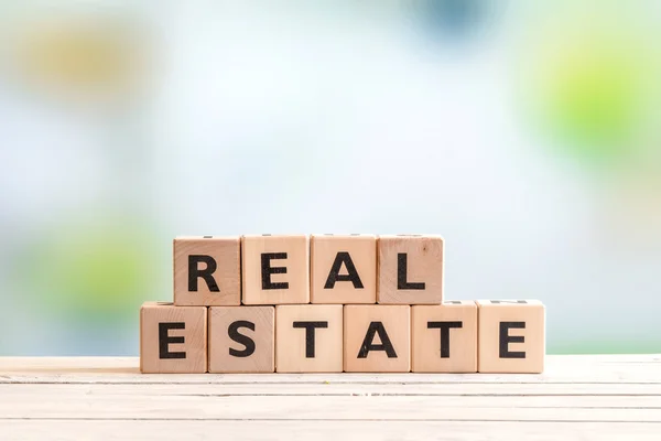 Real estate tecken på ett träbord — Stockfoto