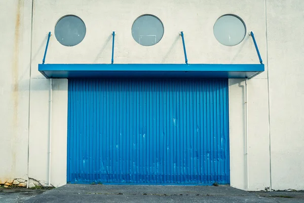 Puerta azul en una pared grumosa — Foto de Stock