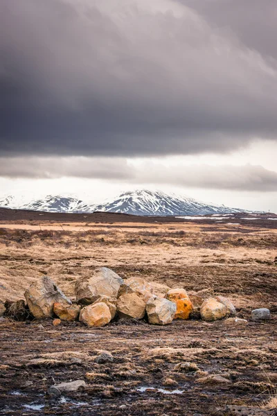 Campo com rochas e montanhas — Fotografia de Stock