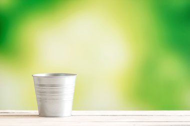 Ahşap bir masa üzerine metal kova