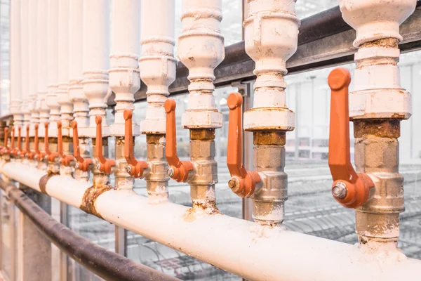 Orange handles on white pipes — Stock Photo, Image