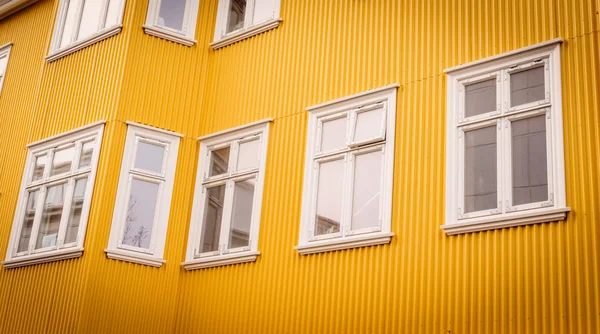 Witte windows op een gele gevel — Stockfoto
