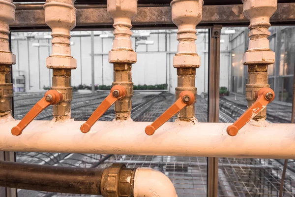 Old pipes with orange handles — Stock Photo, Image