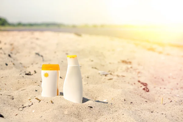 Sunlotion bir plajda kuma — Stok fotoğraf