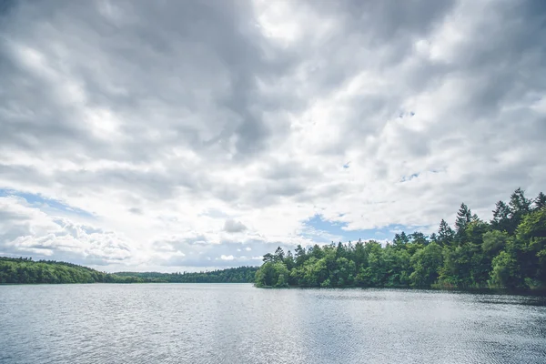 Nuvens escuras sobre um lago florestal — Fotografia de Stock