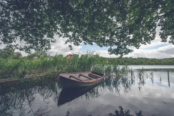 Маленькая лодка среди зеленых тростников — стоковое фото