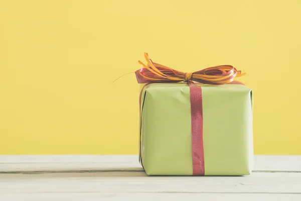 Groen cadeau met een rode en oranje lint — Stockfoto