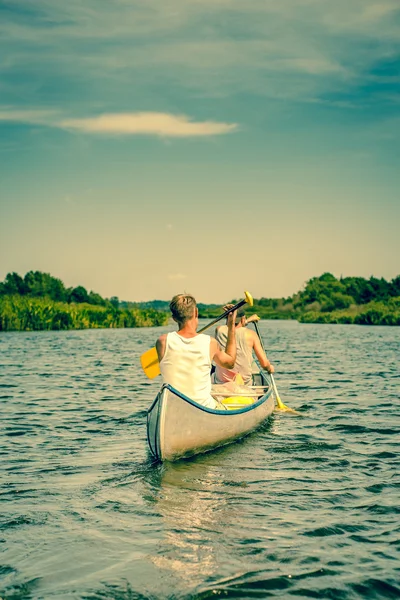 Zwei Männer, die einen Fluss hinunterrudern — Stockfoto