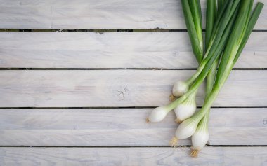 Scallions on a wooden table clipart