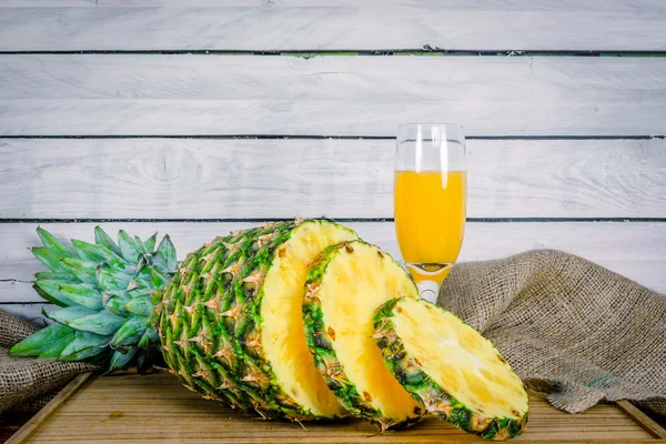 Pineapple and juice on a wooden board — 图库照片