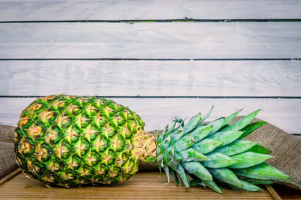 Pineapple on a wooden table with linen — Stockfoto