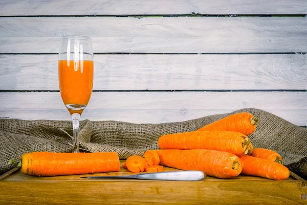 Carrot juice on a wooden board — Stockfoto