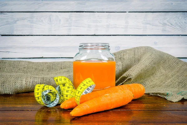 Carrot juice with measure tape on a table — Φωτογραφία Αρχείου