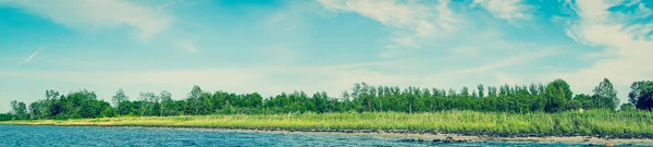 Strand landschap met blauwe water en groene bomen — Stockfoto