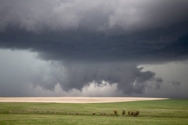Alçak asılı bir duvar bulutu, ovalardaki bir süper hücre fırtınasının altında neredeyse yere değiyor..