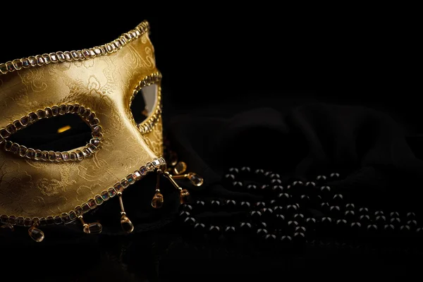 Goldene Maske und Perlen auf Schwarz — Stockfoto