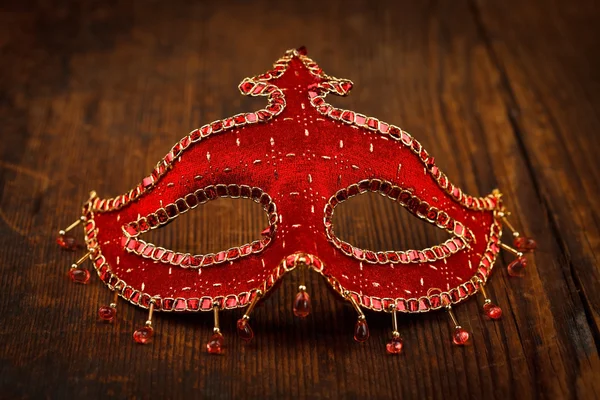 Red carnival mask on wooden table — Stock Photo, Image