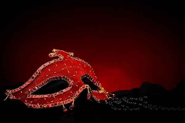 Máscara roja cerca de perlas negras — Foto de Stock