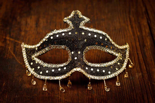 Glittering carnival mask on wooden table — Stock Photo, Image
