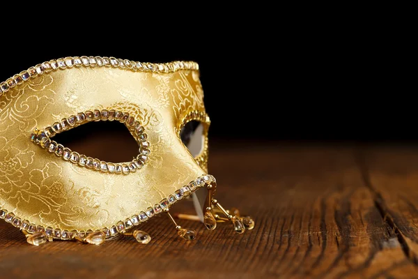 Máscara dourada na mesa de madeira — Fotografia de Stock