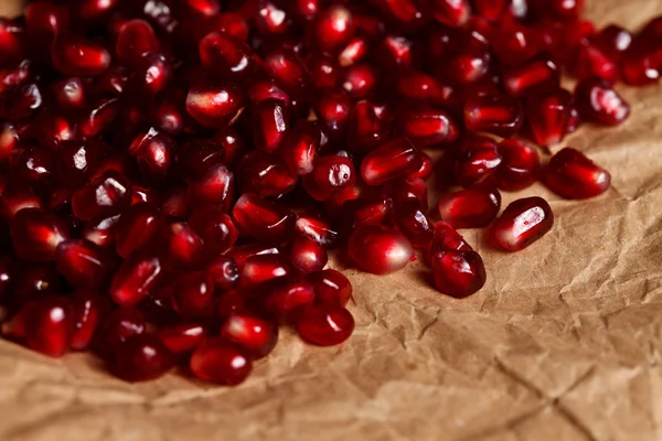 Grenadine seeds on rustic paper — Stock Photo, Image