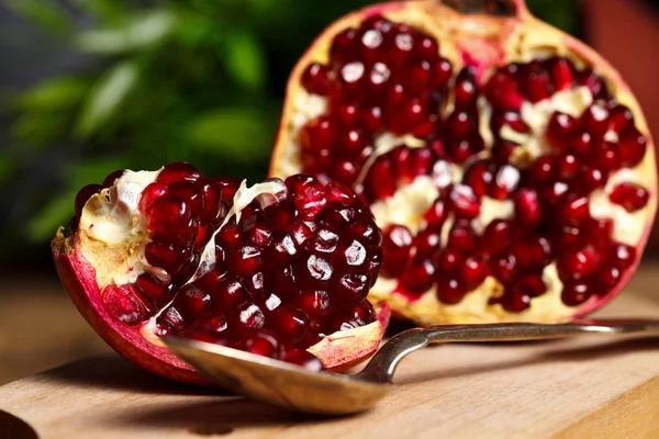 Pomegranate with silver teaspoon — Stock Photo, Image