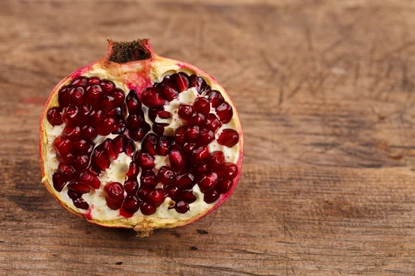 Half grenadine on wooden table — Stock Photo, Image