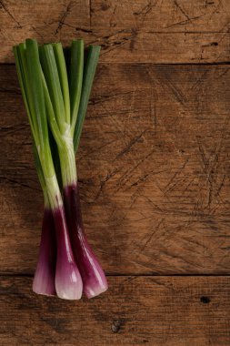 Ahşap masa üzerinde yeşil taze soğan