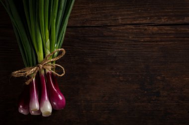 Ahşap masa üzerinde yeşil soğan