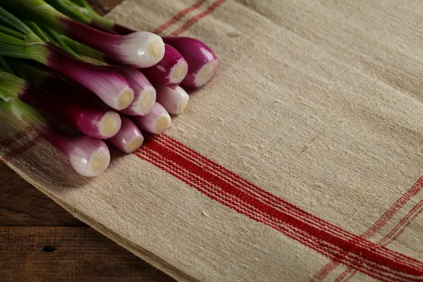 Bunch of onions on the tablecloth — Stock Photo, Image